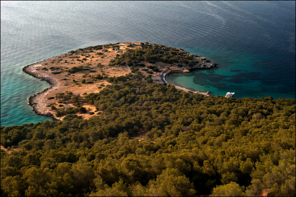 Here's a panoramic view of Moni Island. The photo is taken from the peak of the mountain, and to the right, you can make out the organized beach and harbor where boats from Perdika in Aegina dock.